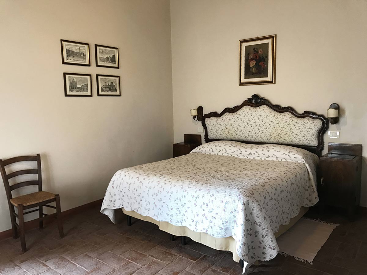 La Loggia third bedroom: large bed and plenty of light for a relaxing stay. Tuscany, Italy